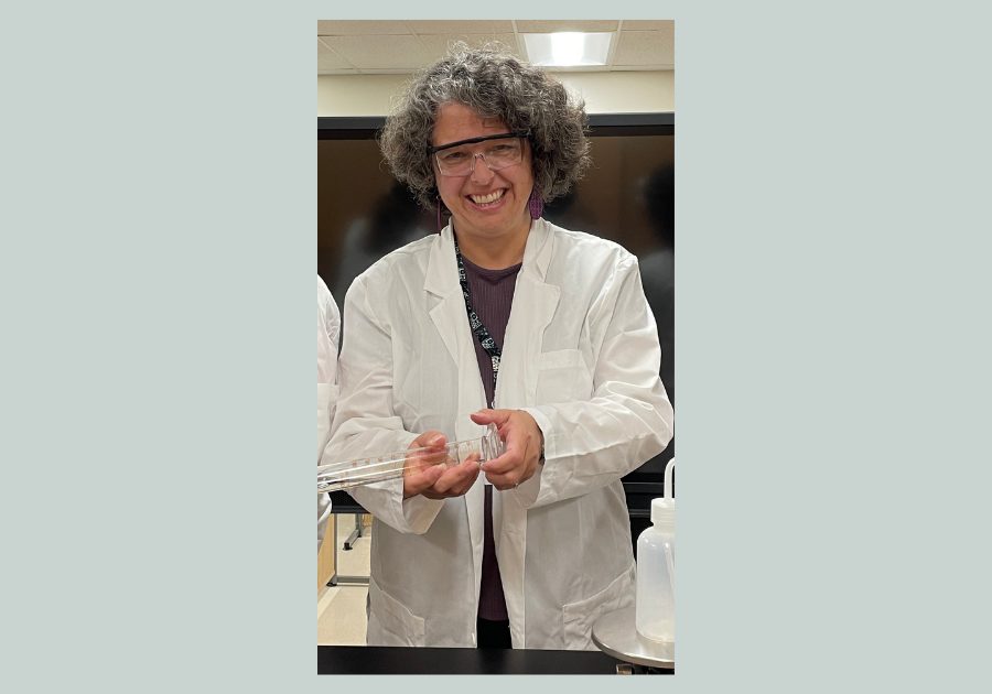 Former teacher demonstrating a classroom science lesson while wearing a lab coat