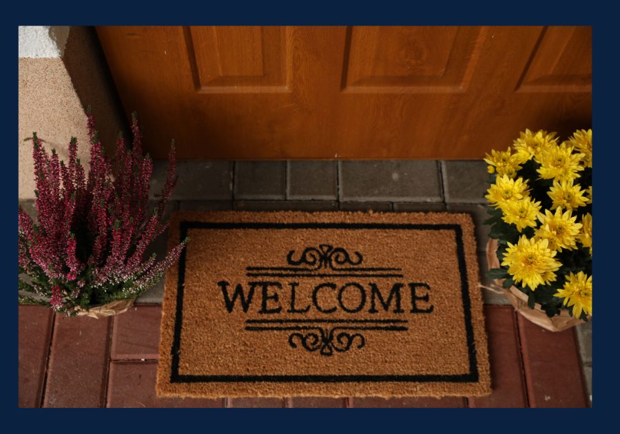 Welcoming front door with welcome mat and flowers creating inviting curb appeal for a home