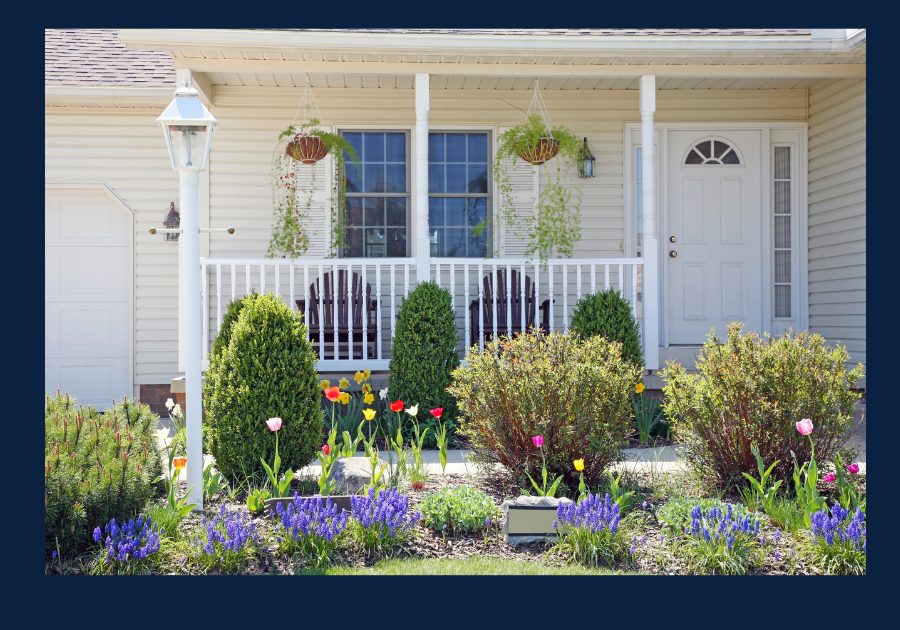 Front porch of an East Tennessee home with spring flowers and landscaped yard
